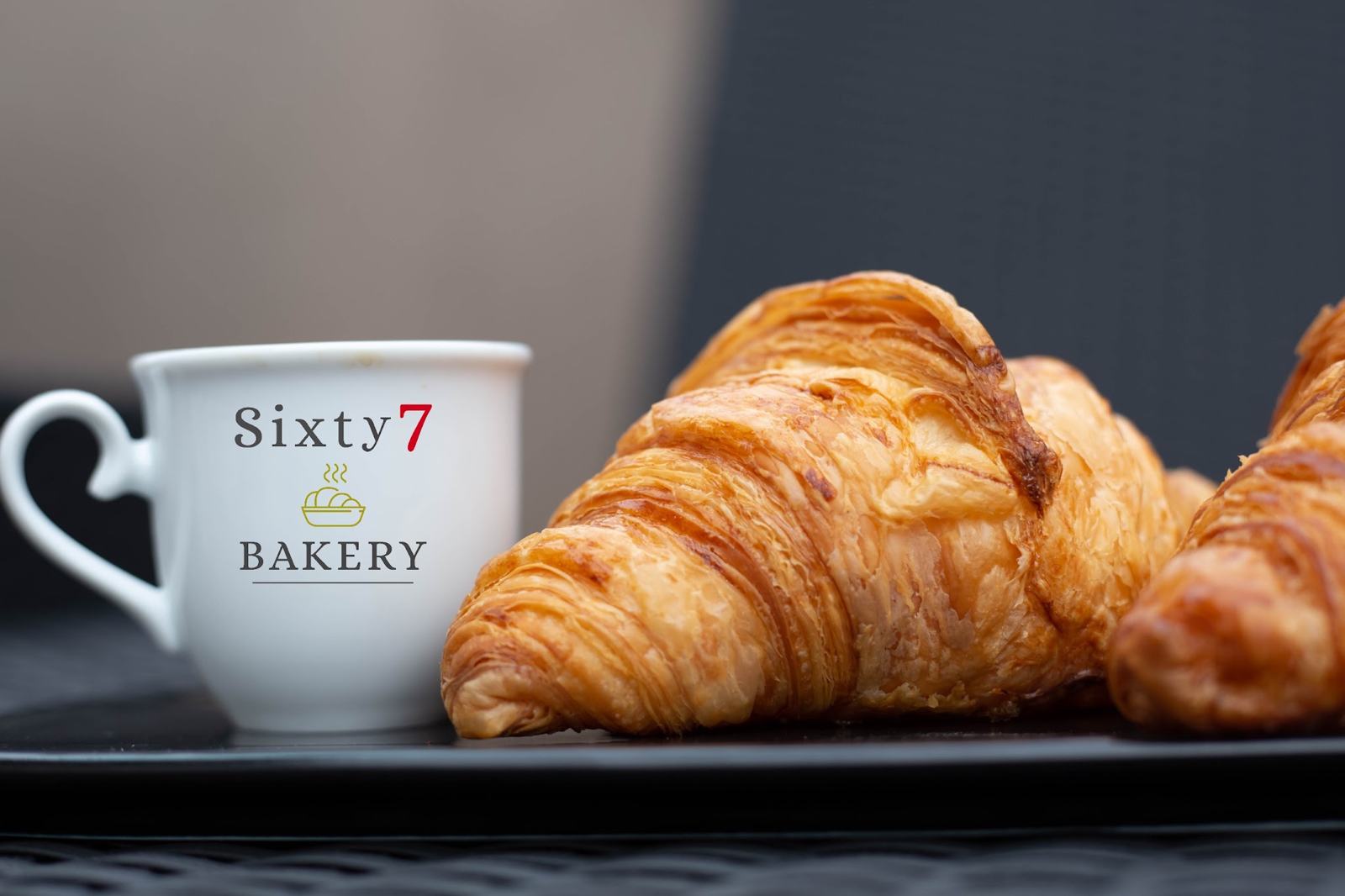 Croissant lângă o cană Sixty 7 Bakery